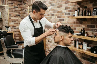 Barbier professionnel réalisant un fade impeccable sur un client dans un salon de coiffure moderne à Lille